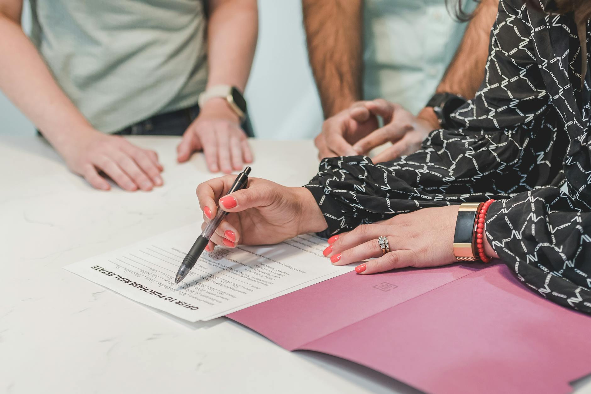 Family member signing estate paperwork at a desk, illustrating naming a payable-on-death beneficiary on a bank account