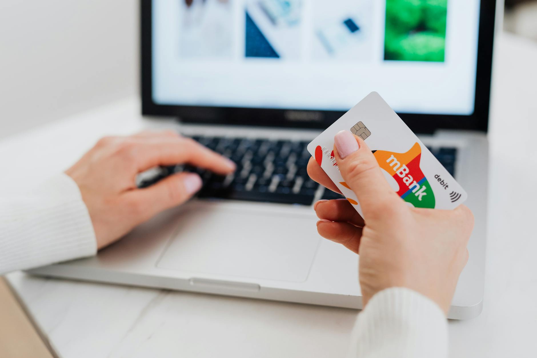 Person using laptop and phone to make a bank transfer between accounts
