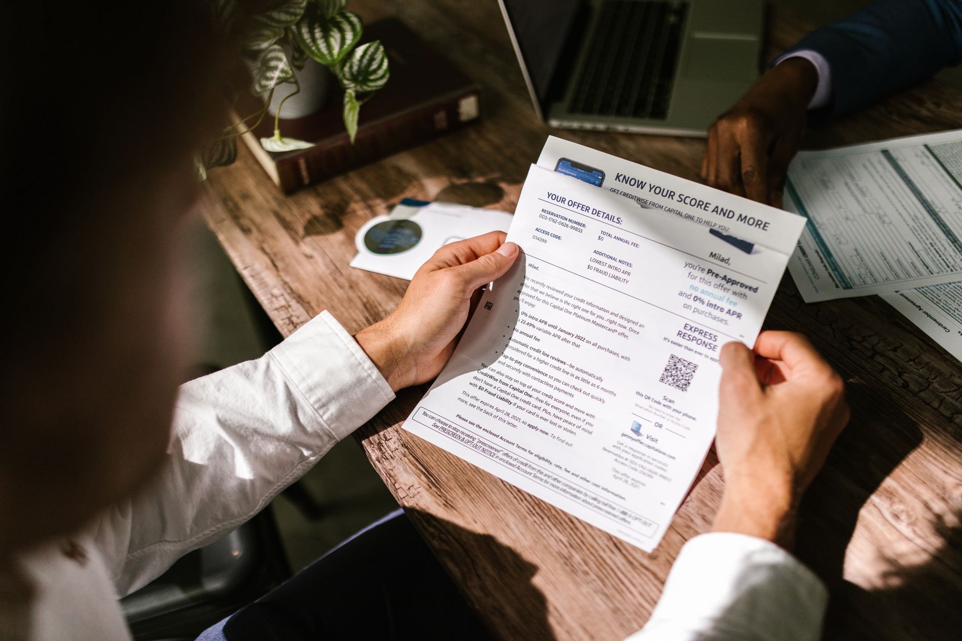 A person reviewing a credit report, illustrating the difference between hard and soft credit inquiries