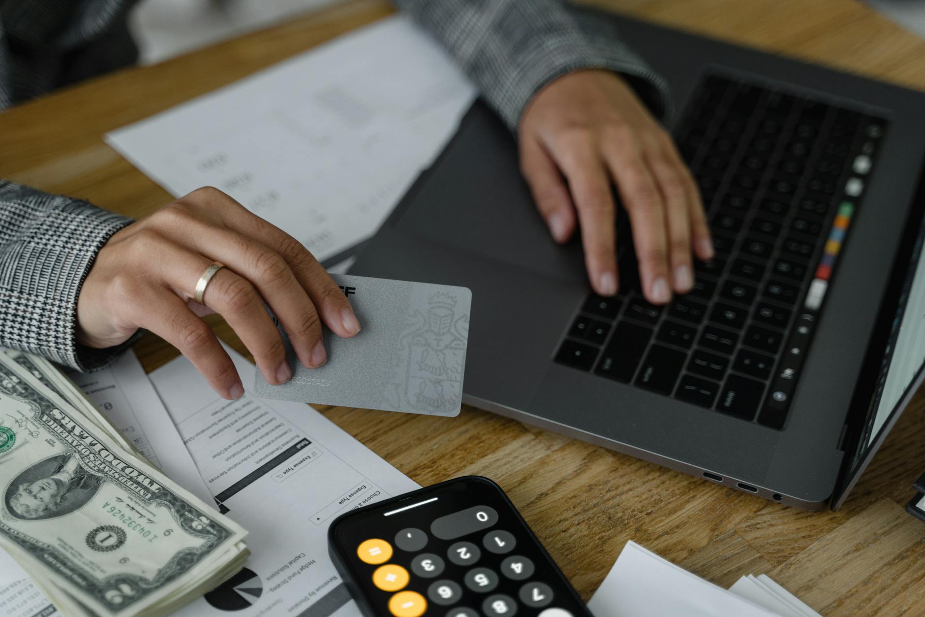 A person holding a credit card next to a billing statement, illustrating how the credit card grace period works.