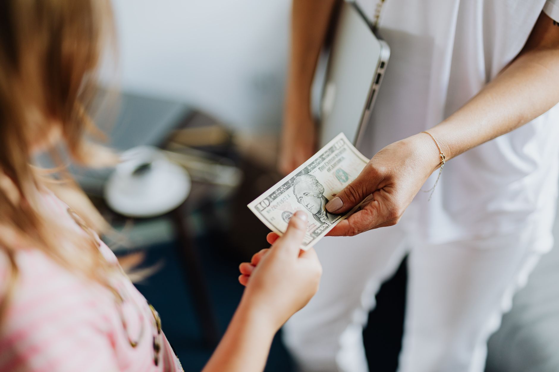 Parent and child putting coins into a piggy bank to save money