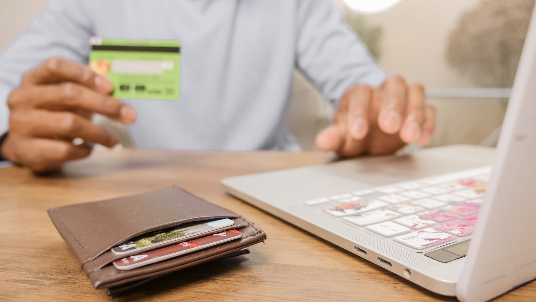 A hand holding several credit cards, representing the major payment card networks