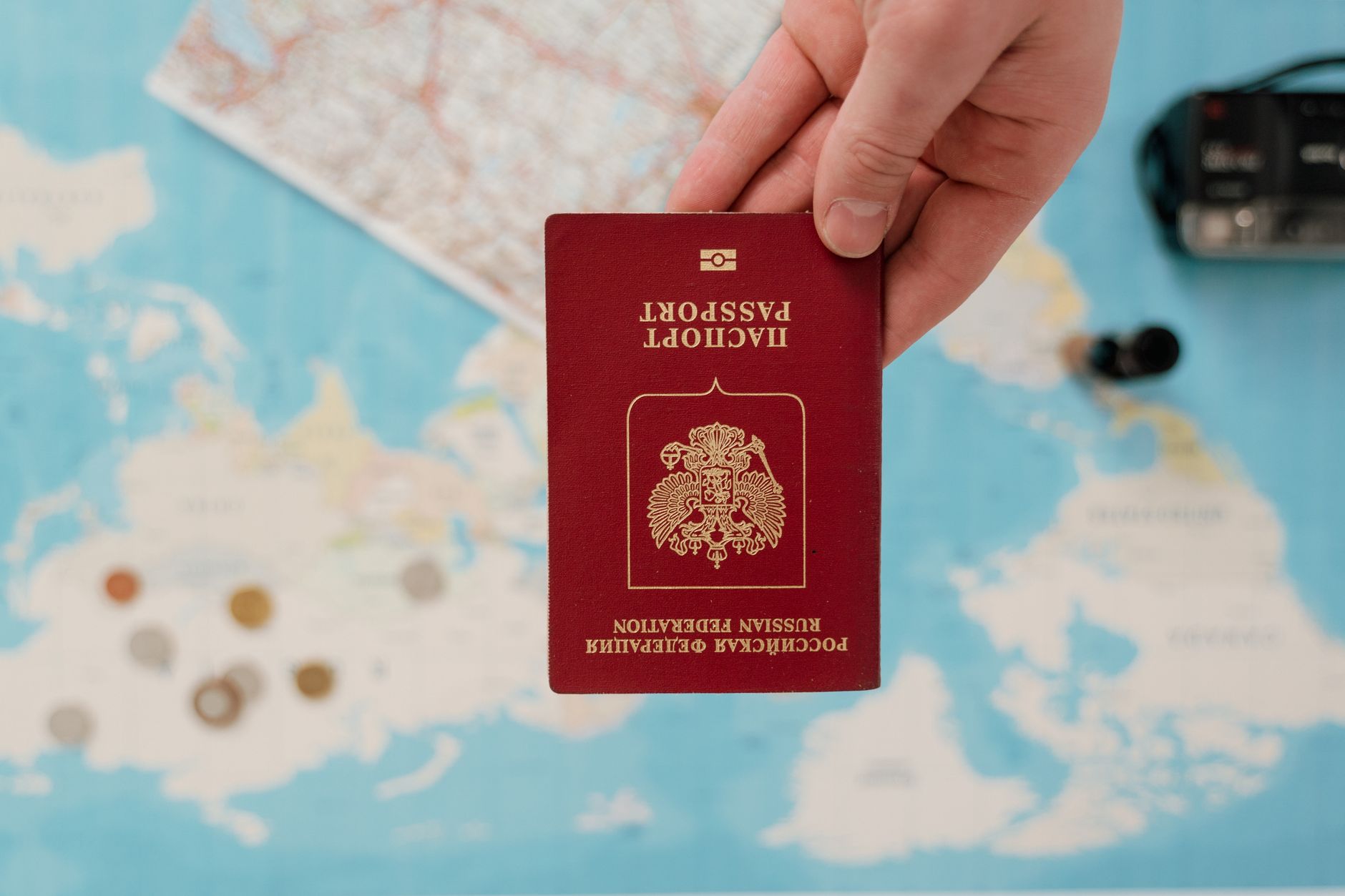 A passport and travel documents on a map, illustrating how travel insurance works and what it covers