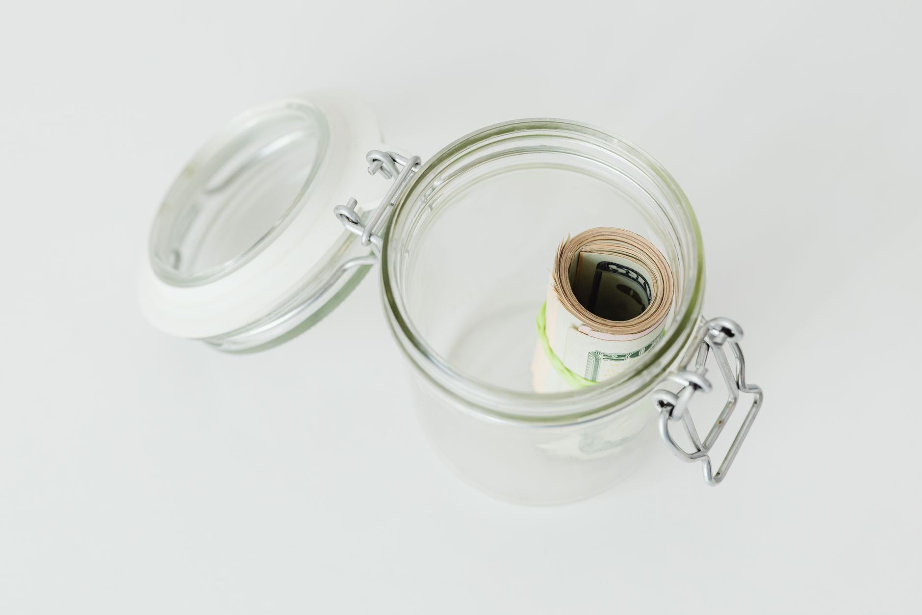 A jar of savings next to retirement planning documents, representing emergency savings accounts