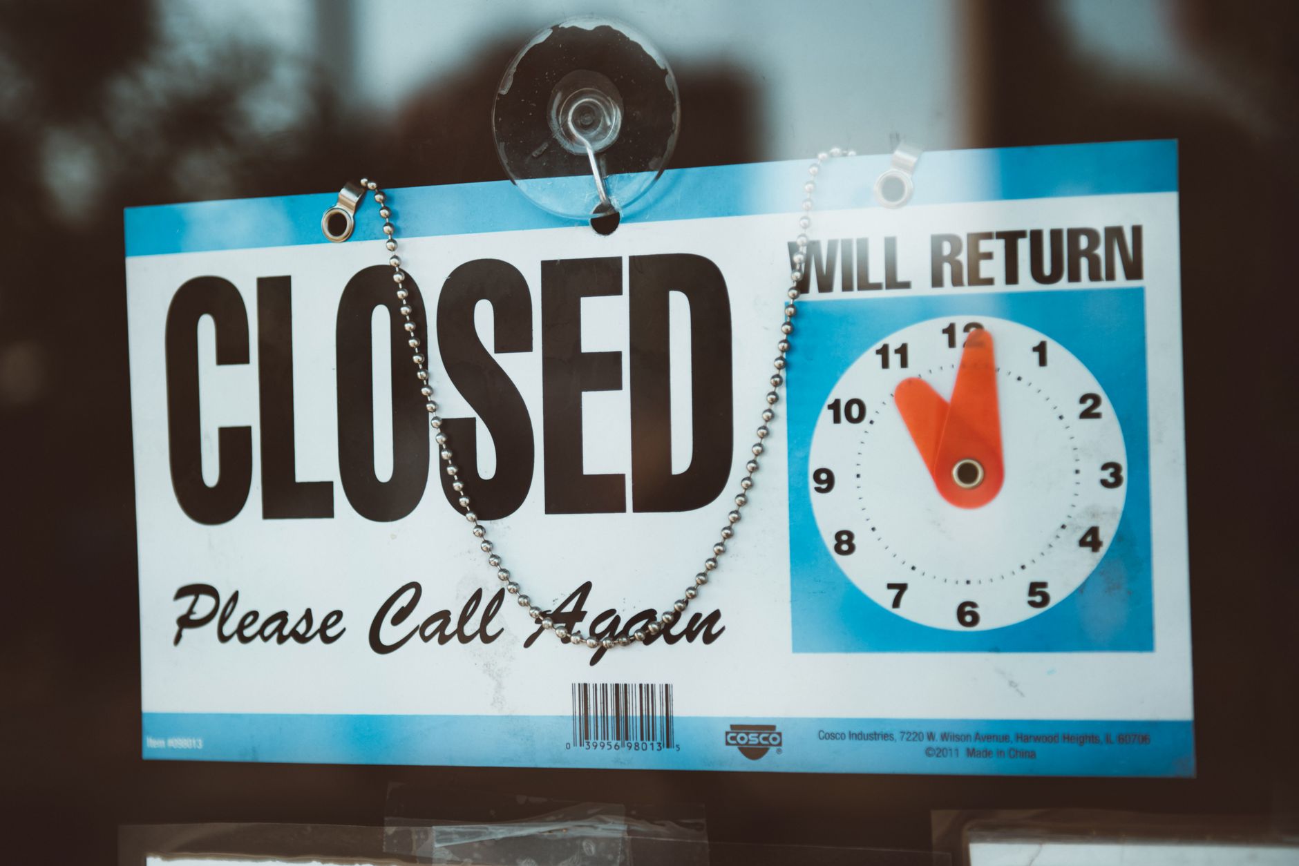 A closed sign on a bank door representing an unexpected bank account closure