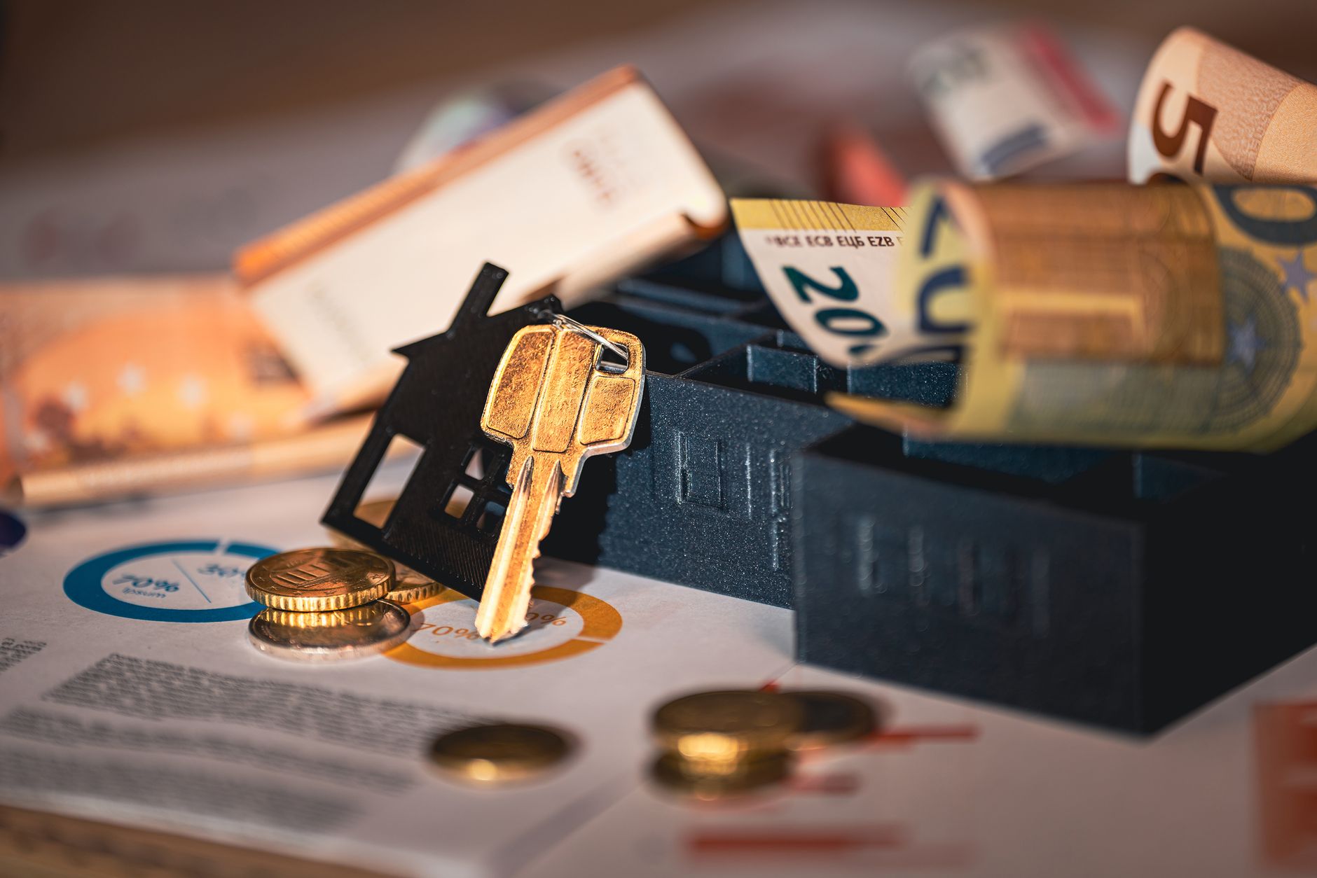 House keys resting on mortgage paperwork and a calculator on a desk
