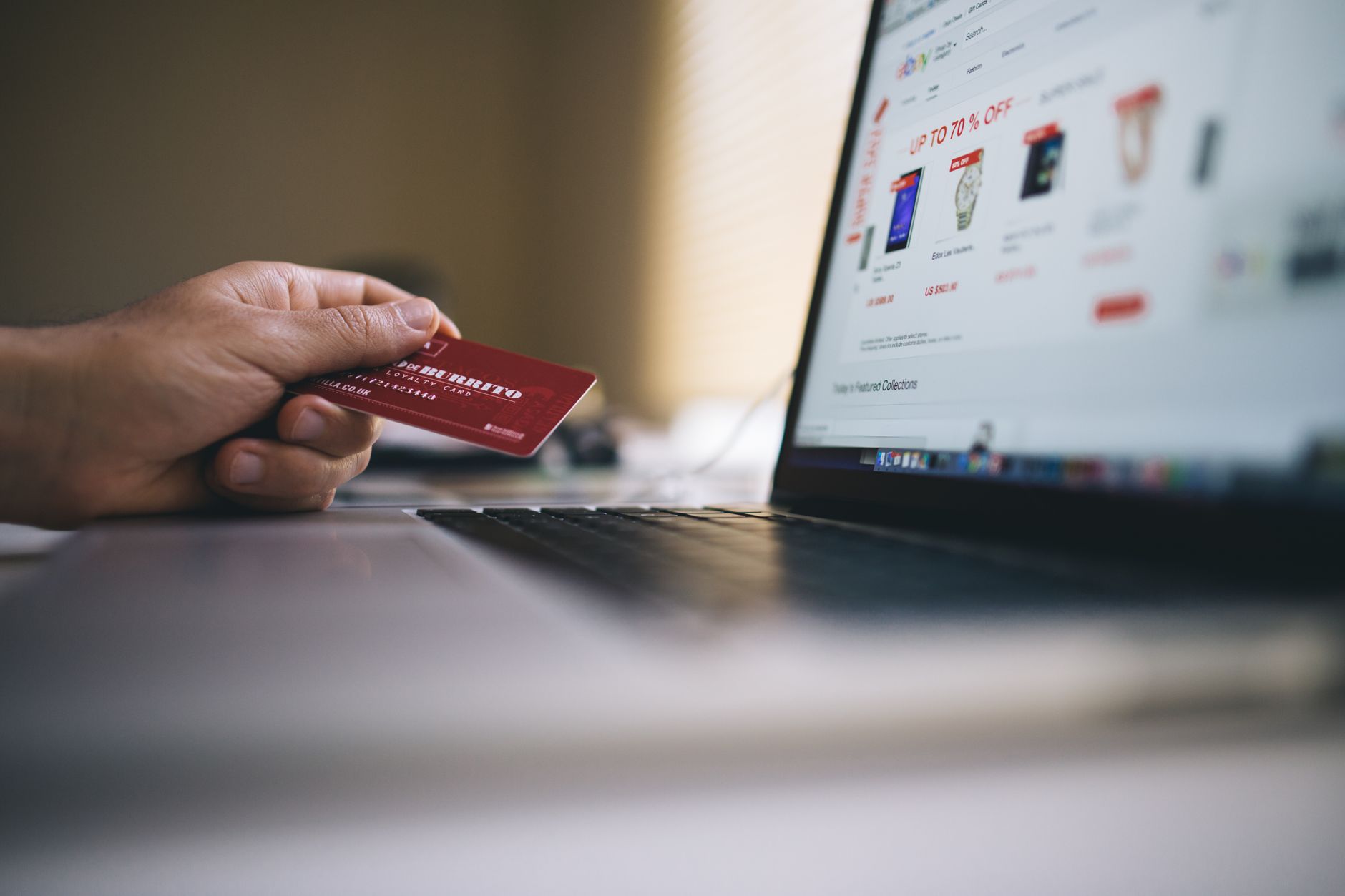 A padlock resting on a laptop keyboard beside a credit card, illustrating how credit freezes work