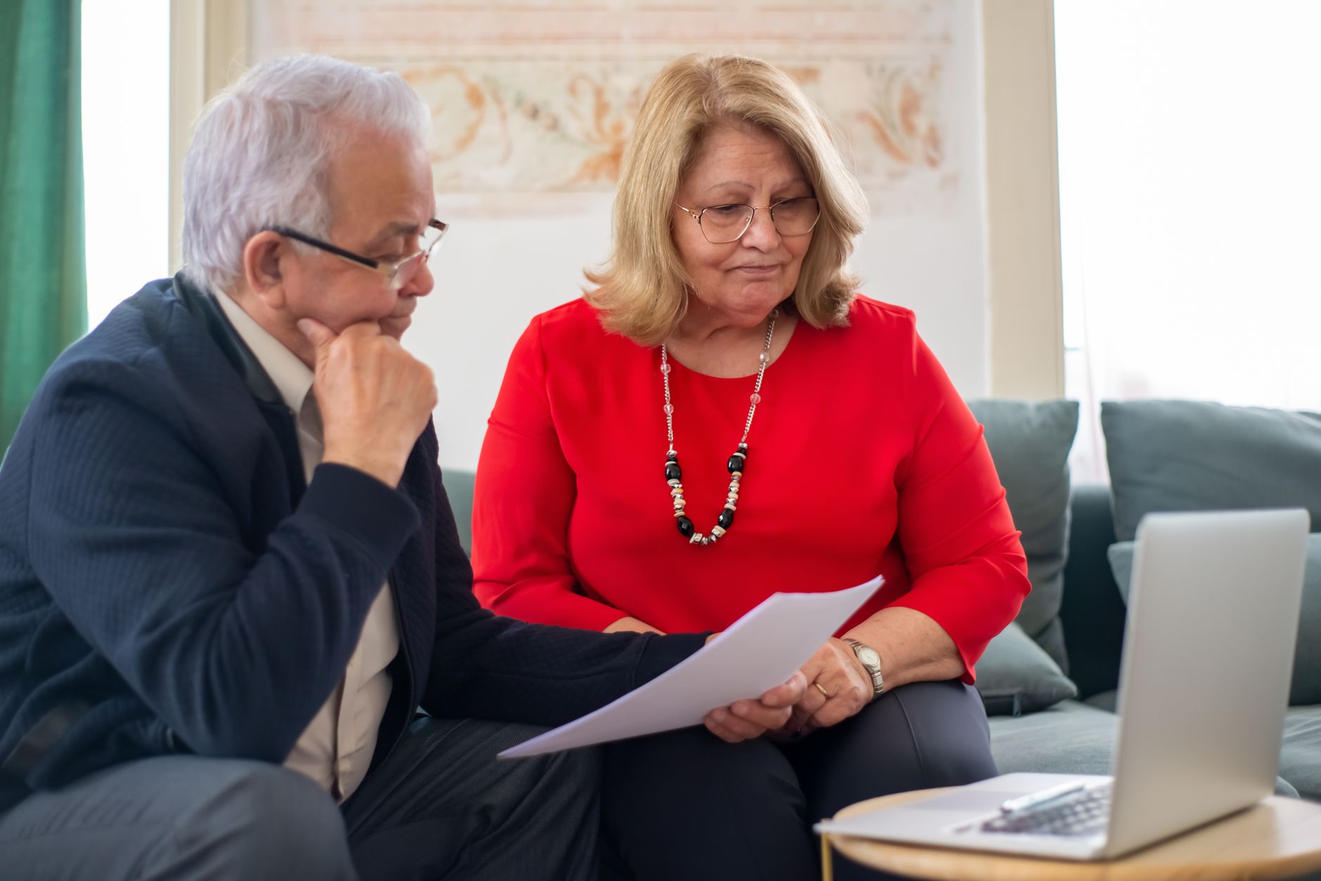 Retired couple reviewing household bills and benefit statements