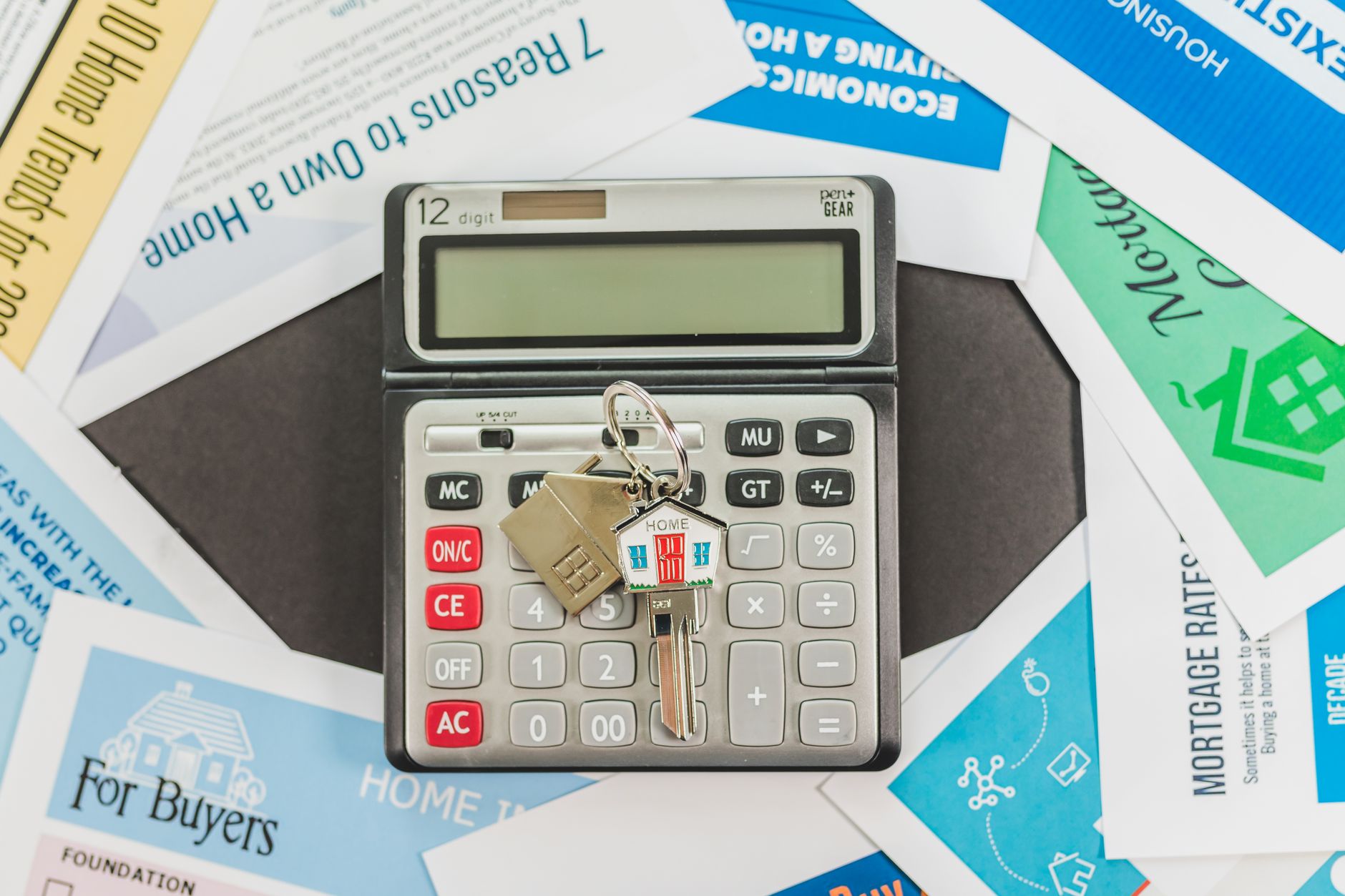 Mortgage loan paperwork with house keys and a calculator on a table
