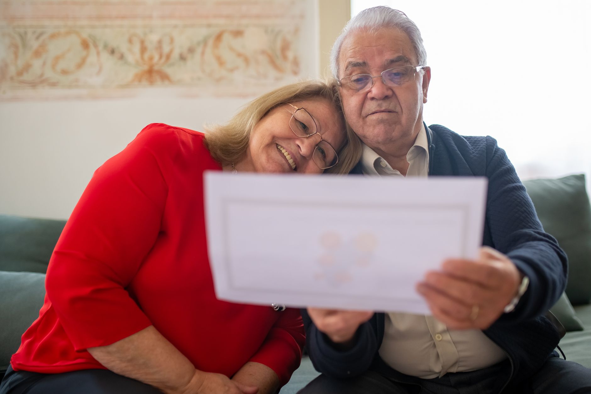 An older couple going over retirement paperwork and Medicare premium statements