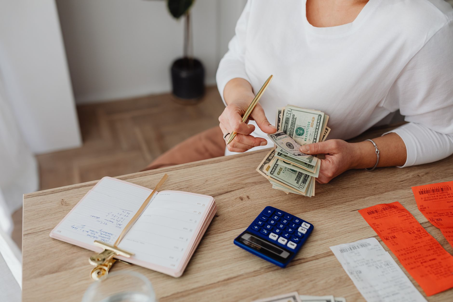 A pay stub and calculator on a desk with a pen