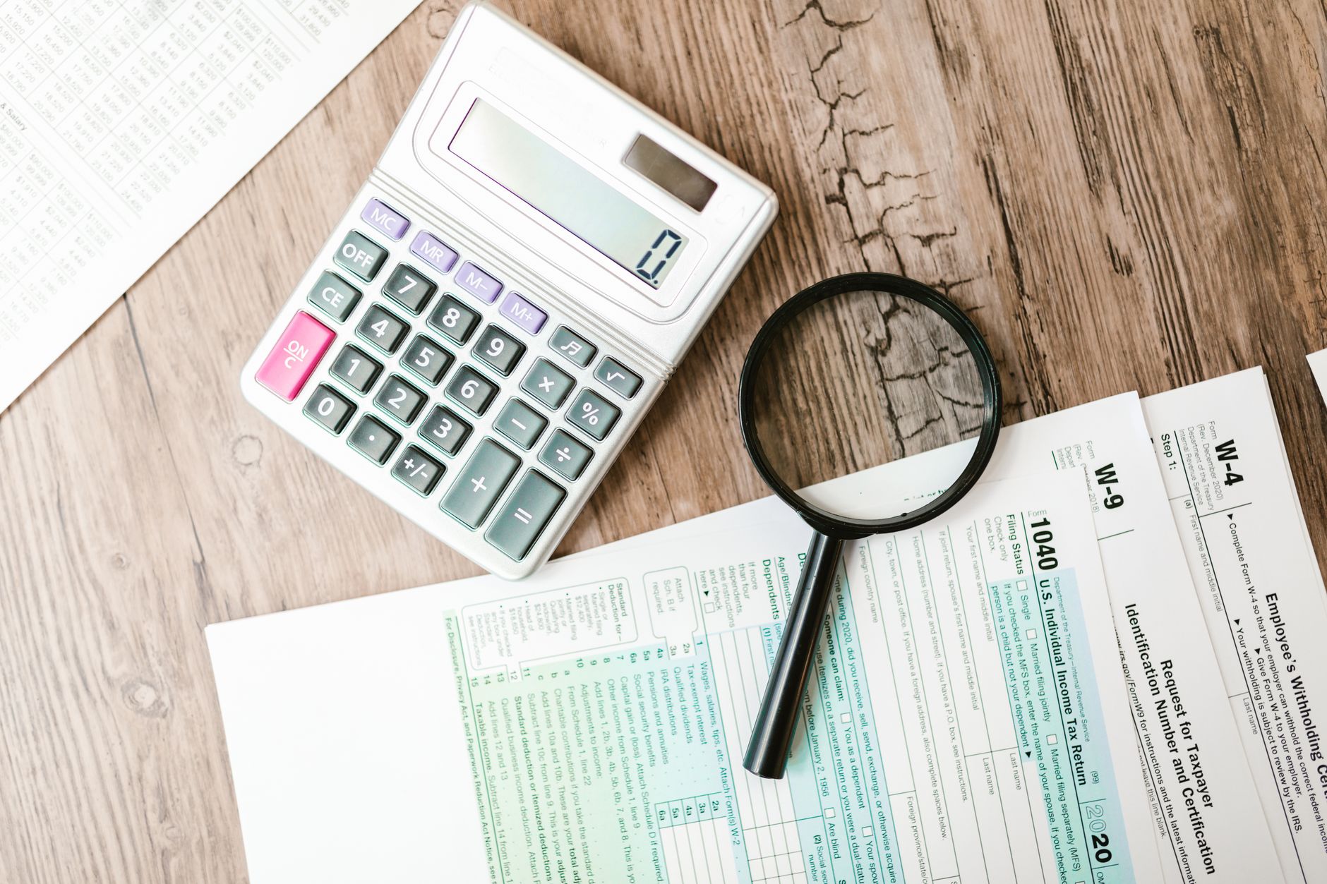 Tax forms, a calculator and investment paperwork on a desk