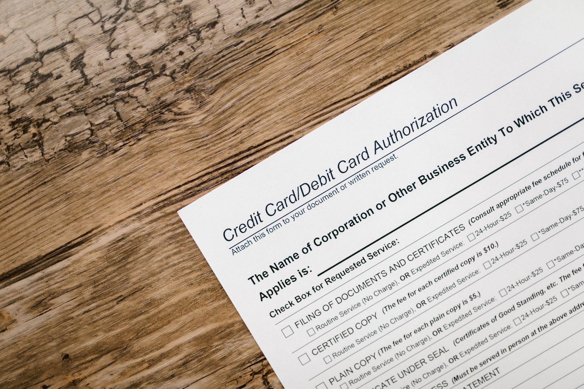 Debit card resting on a printed bank statement showing checking account transactions
