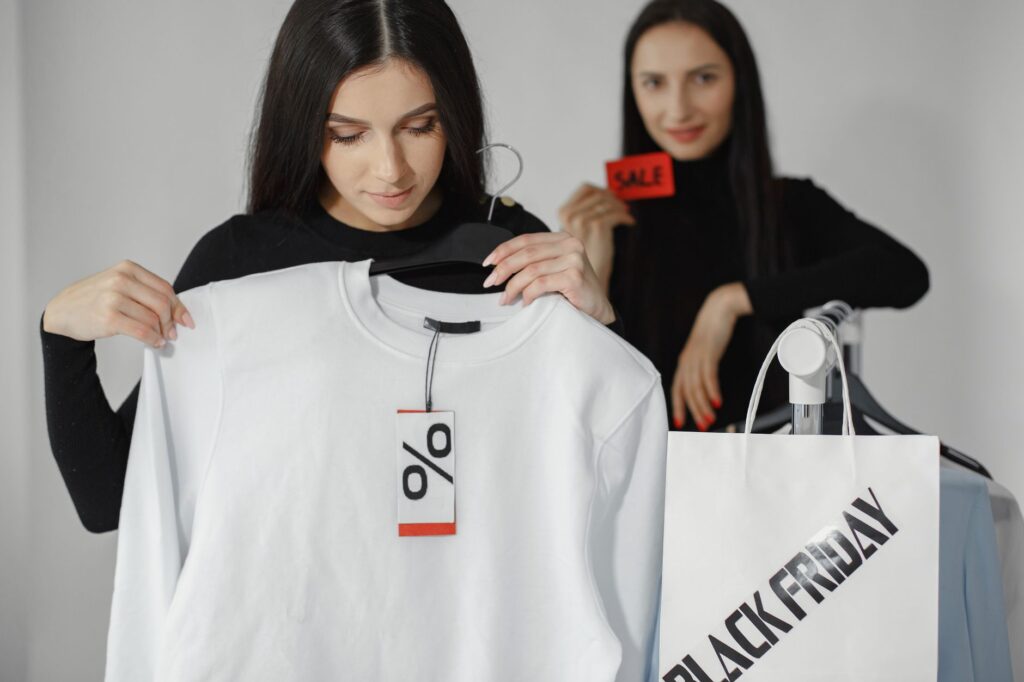 Shopper holding a shirt with a discount tag, illustrating how Black Friday doorbuster sales work