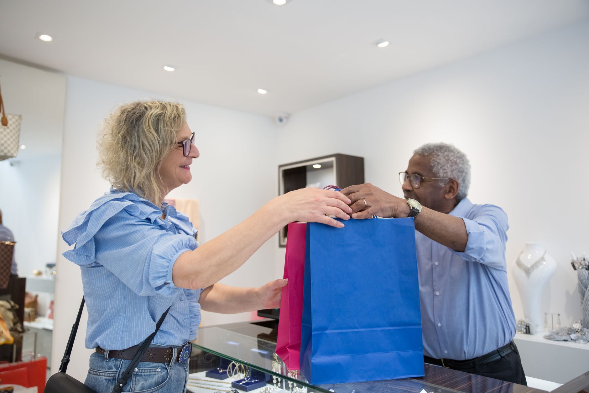 Shopper handing a shopping bag back at a store counter to return a purchase