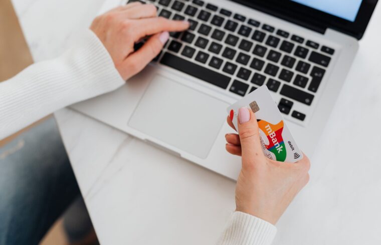 Person holding a credit card at a laptop, illustrating how credit limit increases work