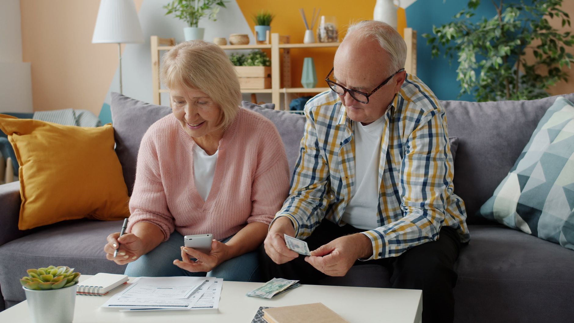 Retired couple reviewing Medicare premium paperwork at home