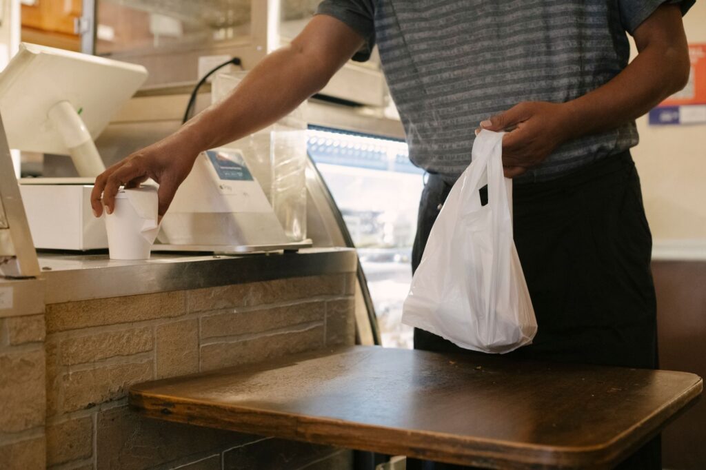 Shopper with shopping bags and a receipt at a store counter, illustrating how retailers track returns