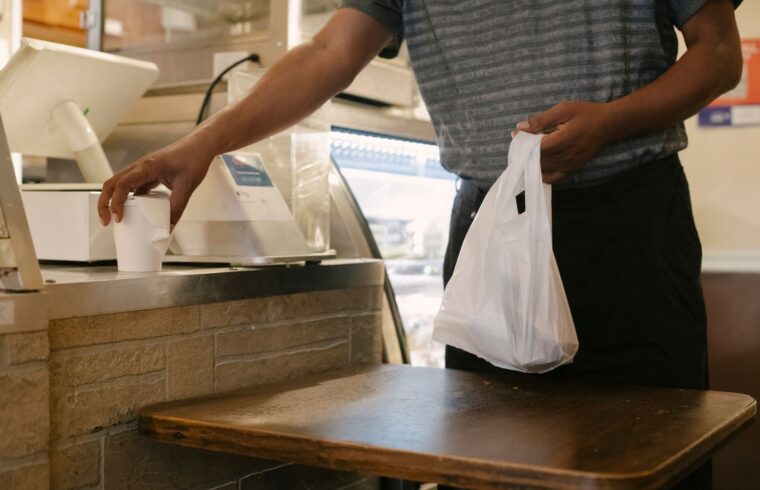 Shopper with shopping bags and a receipt at a store counter, illustrating how retailers track returns